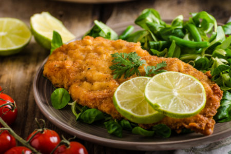 True Viennese schnitzel with little salad and lime, french fries and beautiful cherry tomatoes
